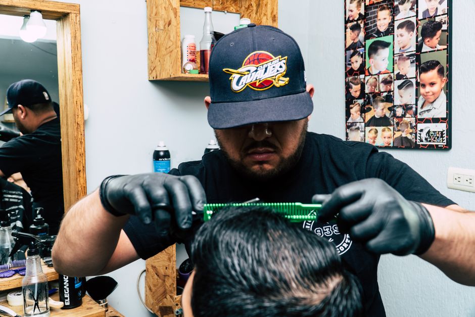 Barber trimming a young client's hair