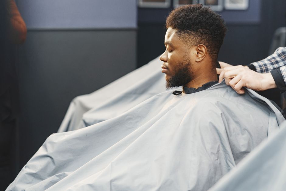 Client draped in a cutting cape, ready for a shave